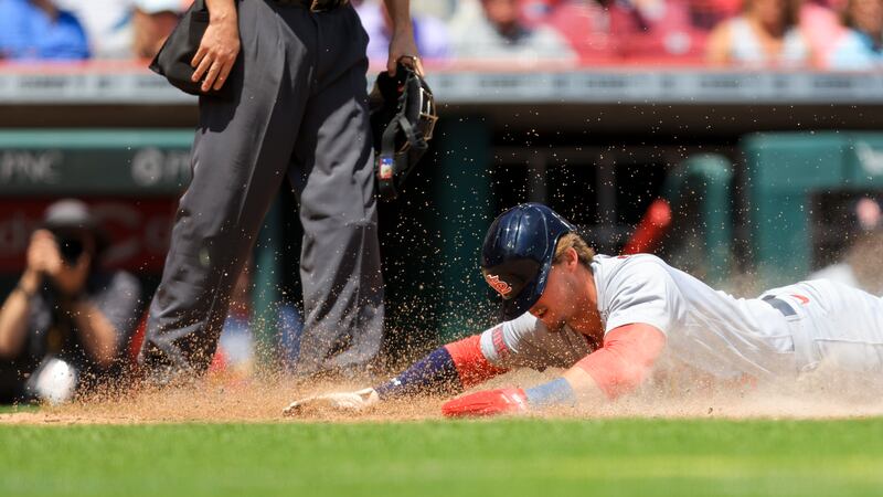 St. Louis Cardinals' Nolan Gorman scores a run on a wild pitch by Cincinnati Reds' Lucas Sims...