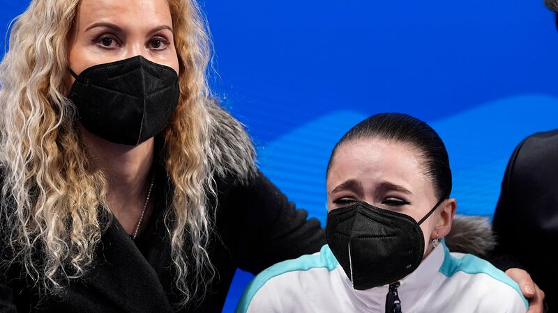 Kamila Valieva, of the Russian Olympic Committee, is embraced by her coach Eteri Tutberidze...