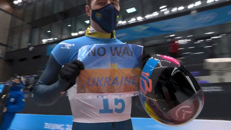 In this frame from video, Vladyslav Heraskevych, of Ukraine, holds a sign that reads "No War...