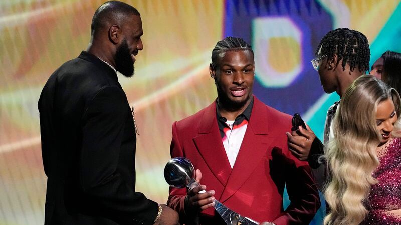 Los Angeles Lakers' LeBron James, left, accepts the award for best record-breaking performance...