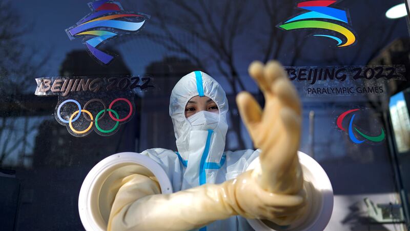 A worker prepares to administer a COVID-19 test at the 2022 Winter Olympics, Tuesday, Feb. 1,...