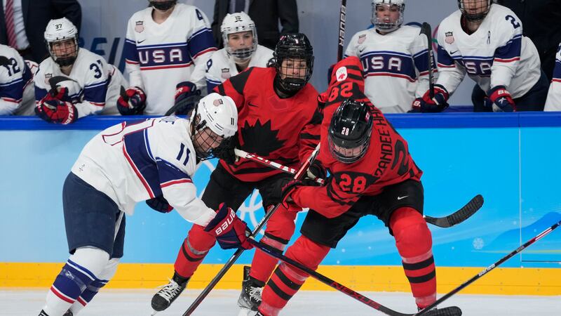 Canada's Micah Zandee-Hart (28) and United States' Abby Roque (11) go for the puck during the...